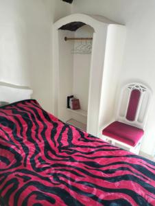 um quarto com uma cama e uma cadeira vermelha em Roma House em Aswan