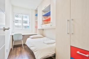 een kleine kamer met een bed en een raam bij Apartamento soleado y acogedor in Barcelona