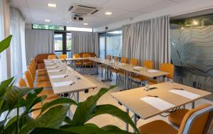 a restaurant with tables and chairs and plants at The Originals Boutique, Hotel l'Occitan, Aubagne in La Destrousse