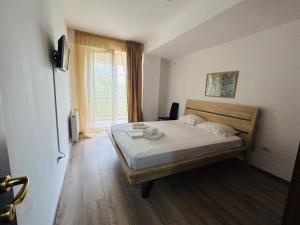 a bedroom with a bed and a large window at Apartament Summerland Mamaia Nord in Mamaia