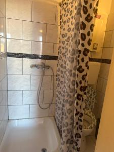 bagno con vasca e servizi igienici con tenda per la doccia. di Dubrovnik1 a Mönchengladbach