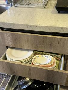 a drawer filled with plates and other dishes at Susana's Baguio Condotel in Baguio