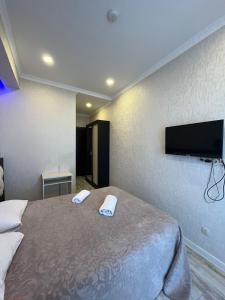a bedroom with a bed with a flat screen tv on the wall at Family Hotel Vere Tower in Tbilisi City