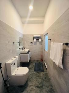 a bathroom with a toilet and a sink at Devon Surf . Inn - Hiriketiya in Dickwella