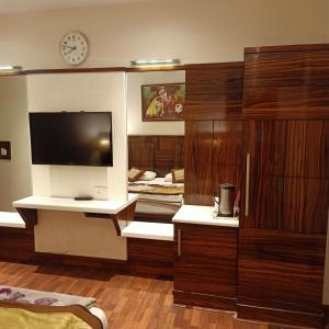 a living room with a large television in a room at hotel geet deluxe in New Delhi
