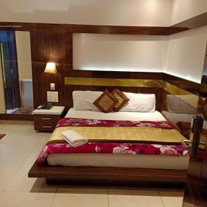 a bedroom with a large bed with a wooden headboard at hotel geet deluxe in New Delhi