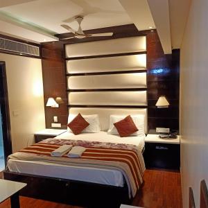 a bedroom with a large bed and two night stands at hotel geet deluxe in New Delhi