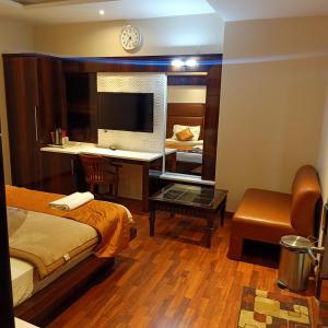 a hotel room with a desk and a bed at hotel geet deluxe in New Delhi
