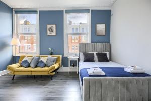 - une chambre avec un lit, un canapé et des fenêtres dans l'établissement Hackney Central Deluxe Apartment, à Londres