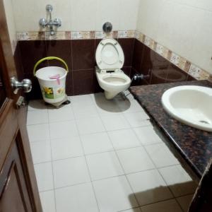 a bathroom with a toilet and a sink at hotel geet deluxe in New Delhi