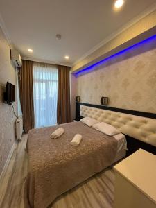 a bedroom with a large bed with two towels on it at Family Hotel Vere Tower in Tbilisi City