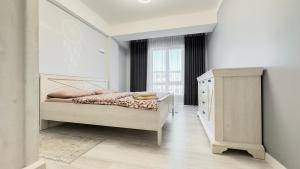 um quarto branco com uma cama e uma janela em Glass New Apartments Ultracentral em Chisinau