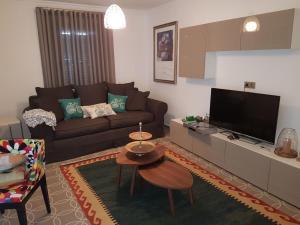 een woonkamer met een bank en een tv bij Villa Hekim in Bodrum City