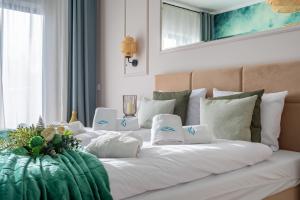 1 cama con almohadas blancas y manta verde en Centrum Park 2 Apartament 8, en Szklarska Poręba