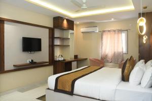 um quarto de hotel com uma cama e uma televisão de ecrã plano em HOTEL IMPERIAL em Aurangābād