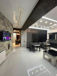 a dining room with tables and a tv on a wall at Family Hotel Vere Tower in Tbilisi City