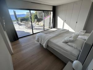 een slaapkamer met een bed en een groot raam bij Villa Les Issambres, 8 pièces, 14 personnes - FR-1-768-62 in Les Issambres