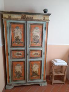 drewniana szafka z obrazami obok stołka w obiekcie Podere Dell'Anselmo w mieście Montespertoli