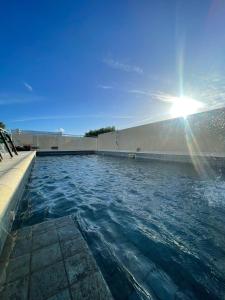 una piscina con el sol en el cielo en Gran Tuyu en San Clemente del Tuyú
