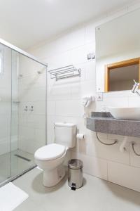 a bathroom with a toilet and a sink and a shower at Hotel Dom Rafael Business in Santa Maria