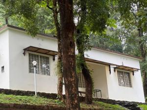 a white building with trees in front of it at GAIRAH RESORT in Mundakāyam