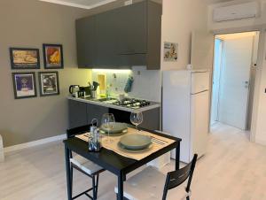een keuken met een tafel en een witte koelkast bij Collecchio Mini House in Collecchio