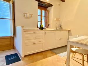 een keuken met witte kasten en een wastafel bij La Vernaccia - Torre del Colle, Bevagna in Torre del Colle