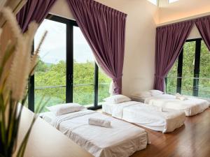 Três camas num quarto com janelas grandes em Seri Kembangan Equine Villa with Pool by Iconique em Seri Kembangan