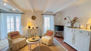een woonkamer met 2 stoelen en een tafel bij Maison de village en 2 parties in Saint-Clément-des-Baleines