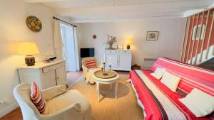 een woonkamer met een bank, stoelen en een tafel bij Maison de village en 2 parties in Saint-Clément-des-Baleines