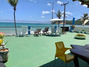 um pátio com cadeiras e mesas e o oceano em Ponta Negra Suites & Apart em Natal