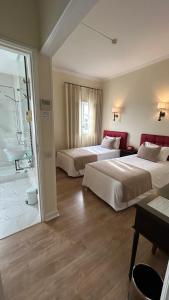 a hotel room with two beds and a bathroom at Hotel Joao Padeiro in Aveiro