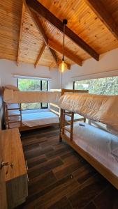 a room with three bunk beds and a wooden ceiling at Finca la Esperanza Casa para 7 Personas Ubaté Cundinamarca in Ubaté