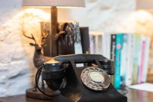 een telefoon op een tafel naast een lamp bij The Converted Stables - A Characterful Mews House in Edinburgh