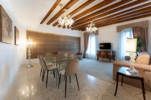 ein Wohnzimmer mit einem Tisch, Stühlen und einem Sofa in der Unterkunft San Teodoro Palace - Luxury Apartments in Venedig
