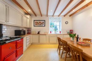 een grote keuken met een houten tafel en een aanrecht bij The Converted Stables - A Characterful Mews House in Edinburgh