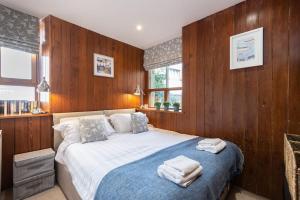 een slaapkamer met een groot bed en houten wanden bij The Converted Stables - A Characterful Mews House in Edinburgh