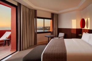 a hotel room with a bed and a window at Tivoli La Caleta Resort in Adeje