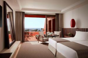 a hotel room with a bed and a balcony at Tivoli La Caleta Resort in Adeje