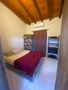 Dormitorio pequeño con cama con manta morada en Hermosa Casa en San Bernardino, en San Bernardino