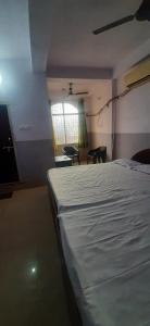 a bedroom with a bed and chairs and a window at SPOT ON Gajadhar Rest House in Deoghar
