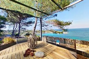 a wooden table with a vase sitting on a table with the ocean at Résidences Sopramare in Algajola