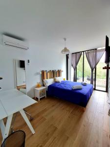 um quarto com uma cama azul e uma mesa em Mitjana's House em Cala Galdana
