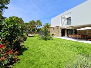 um jardim com relvado em frente a uma casa em Mitjana's House em Cala Galdana