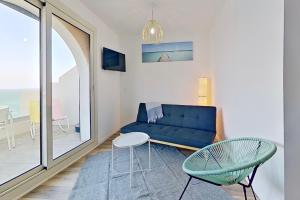 uma sala de estar com um sofá azul e uma mesa em Résidences Sopramare em Algajola