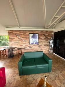 a living room with a green couch and a brick wall at Mesod Jungle Boutique in Caracas