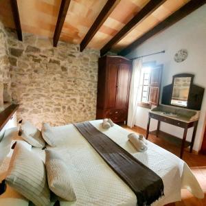 Ce lit se trouve dans un dortoir doté d'un mur en pierre. dans l'établissement Agroturismo Son Torrat Apartment Ses Solls, à Petra