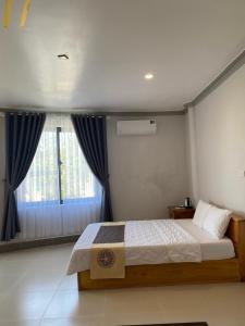a bedroom with a bed and a large window at H&ograve;n Cau Resort & Restaurant in Tuy Phong