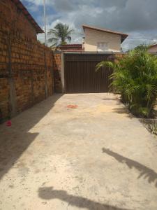 a driveway in front of a house with a brick wall at CASA DE TEMPORADA in Barreirinhas