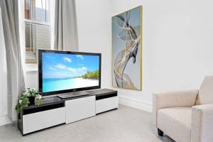 a living room with a television and a couch at Modern 4B2B house@Glebe in Sydney